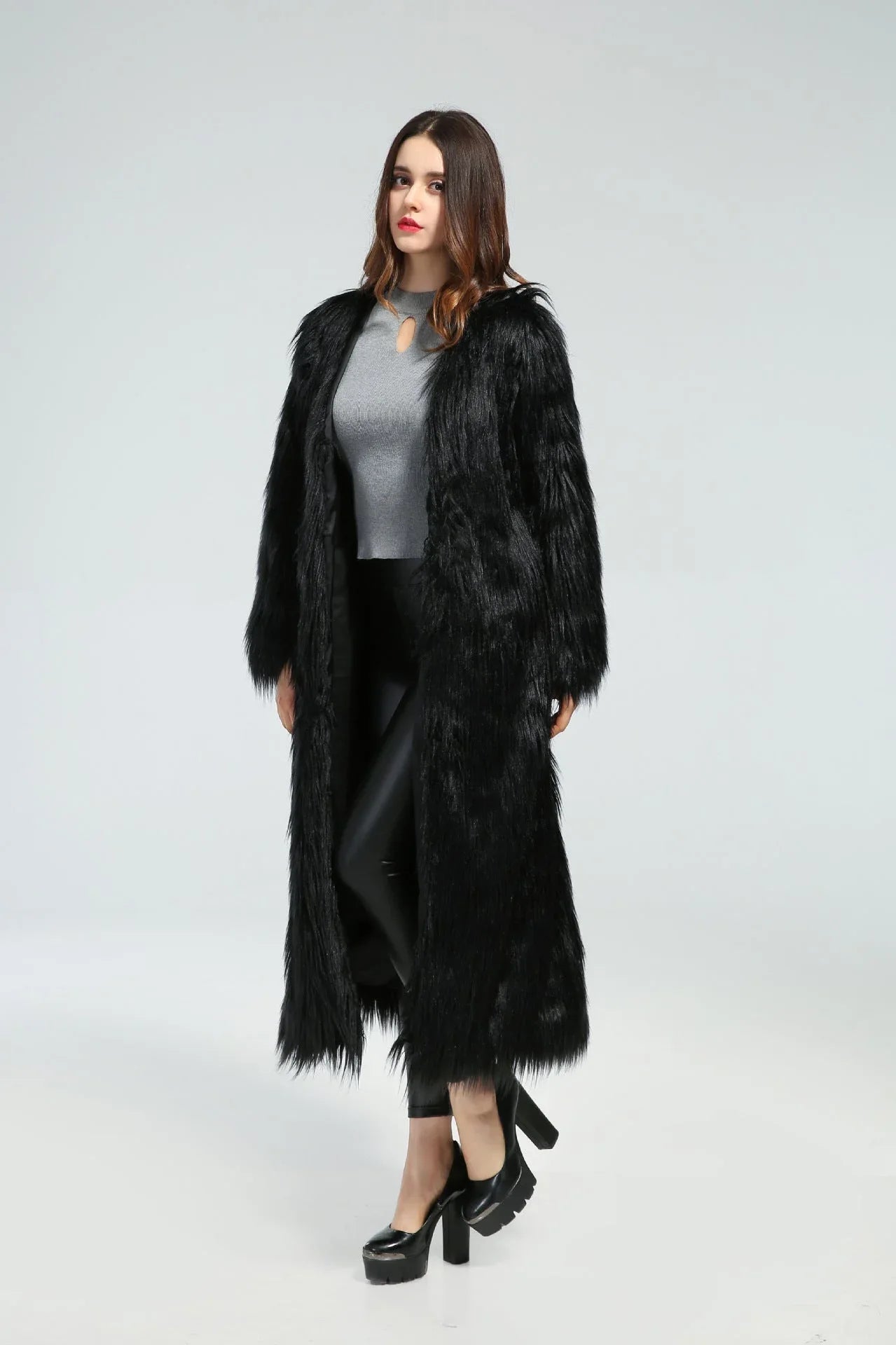 Full-length view of a woman in a black longline faux fur coat.