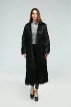 Front view of a woman modeling a black longline faux fur coat.