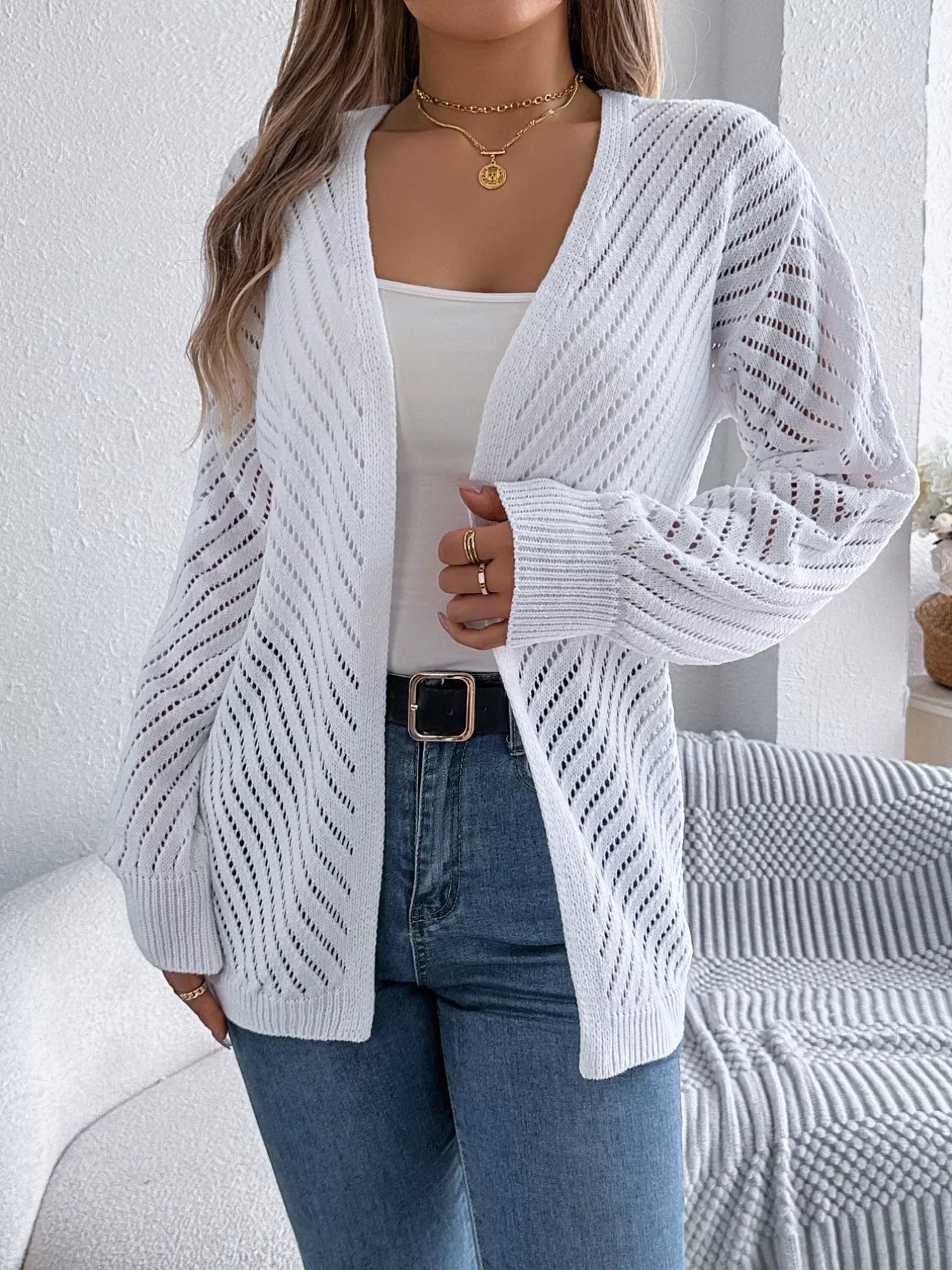 Close-up of the intricate knit pattern on a white cardigan
