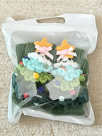 Pair of green crew socks with 3D Christmas tree appliques in a clear bag