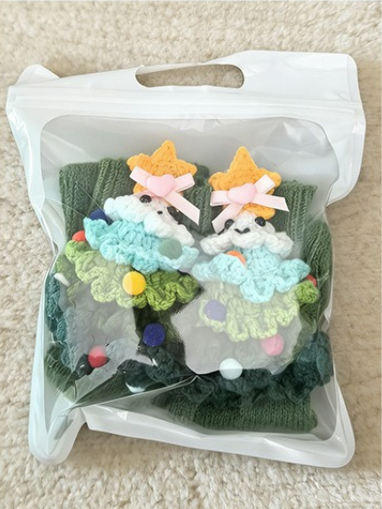 Pair of green crew socks with 3D Christmas tree appliques in a clear bag