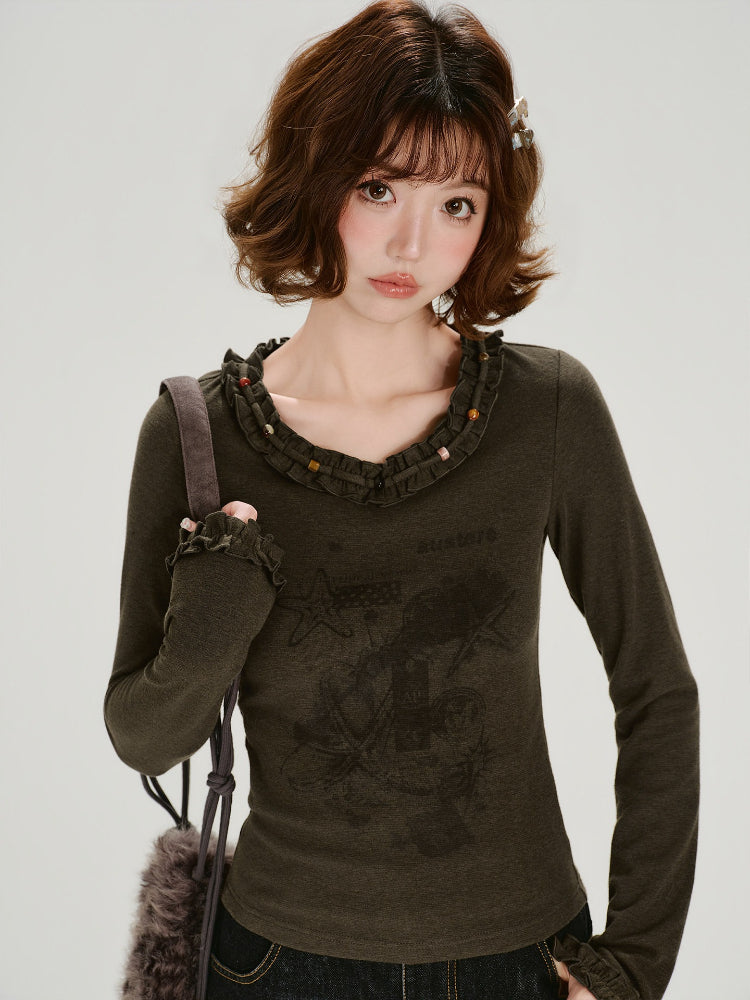 Side view of the woman wearing the graphic t-shirt, highlighting the long sleeves and fitted silhouette.
