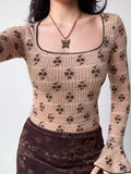 Model displaying a fitted long-sleeved top with a vintage-inspired floral pattern.