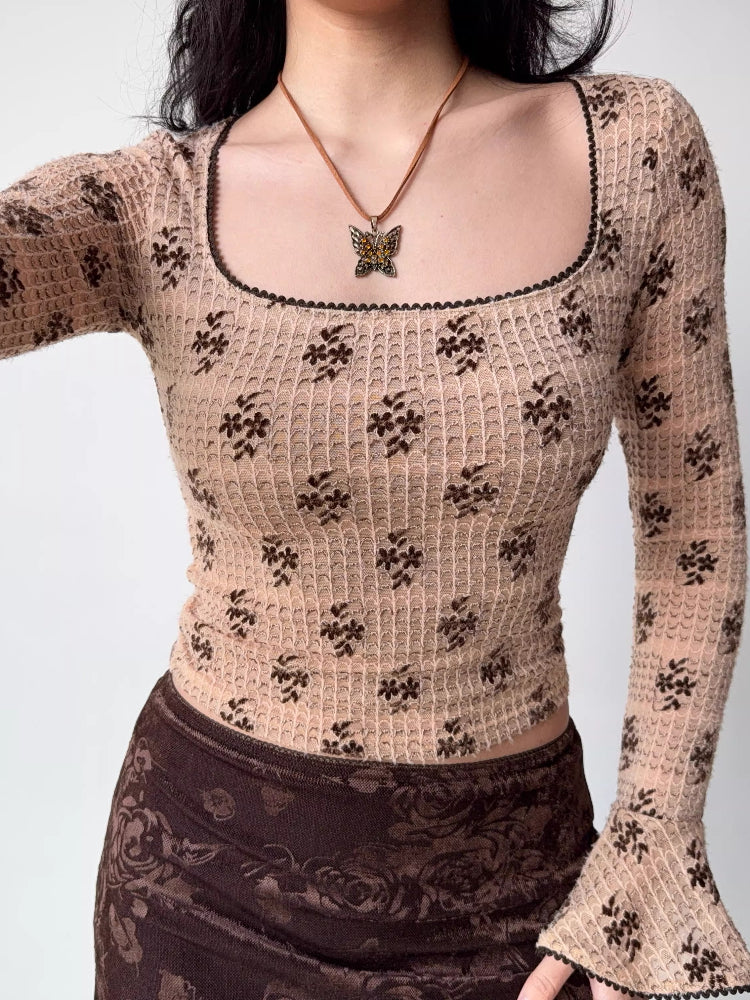 Model displaying a fitted long-sleeved top with a vintage-inspired floral pattern.