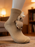 Beige knitted ankle socks with a crochet sheep and duck applique on the side, displayed on a mannequin foot.