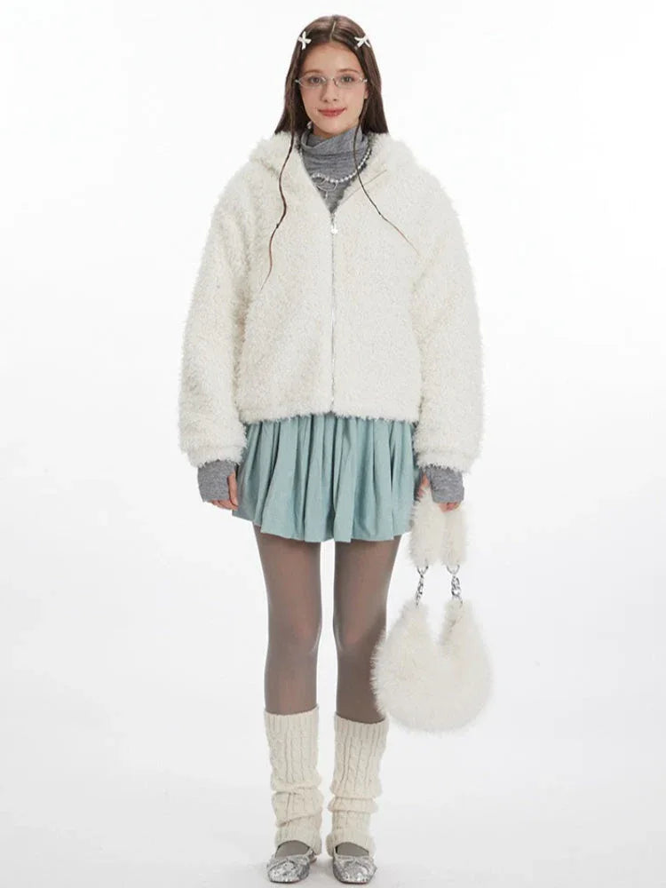 Woman wearing a white fuzzy fleece hooded jacket with bunny ears, a grey turtleneck, a light blue pleated skirt, grey tights, and white leg warmers. Main image