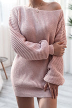 Model posing in a pink off-the-shoulder knit tunic sweater