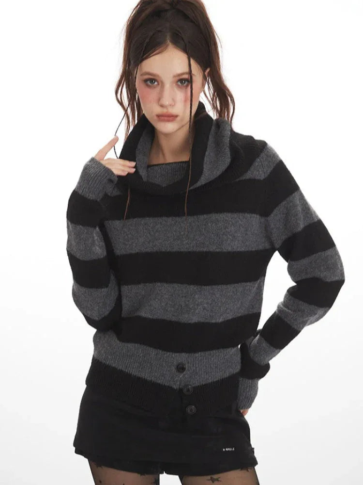 Woman wearing a grey and black striped knit sweater with a cowl neck, black shorts, black patterned tights, and black boots.