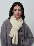 Woman wearing a cream-colored ribbed knit scarf