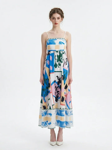 Woman wearing a white midi dress with an abstract botanical print and spaghetti straps, standing against a white background.
