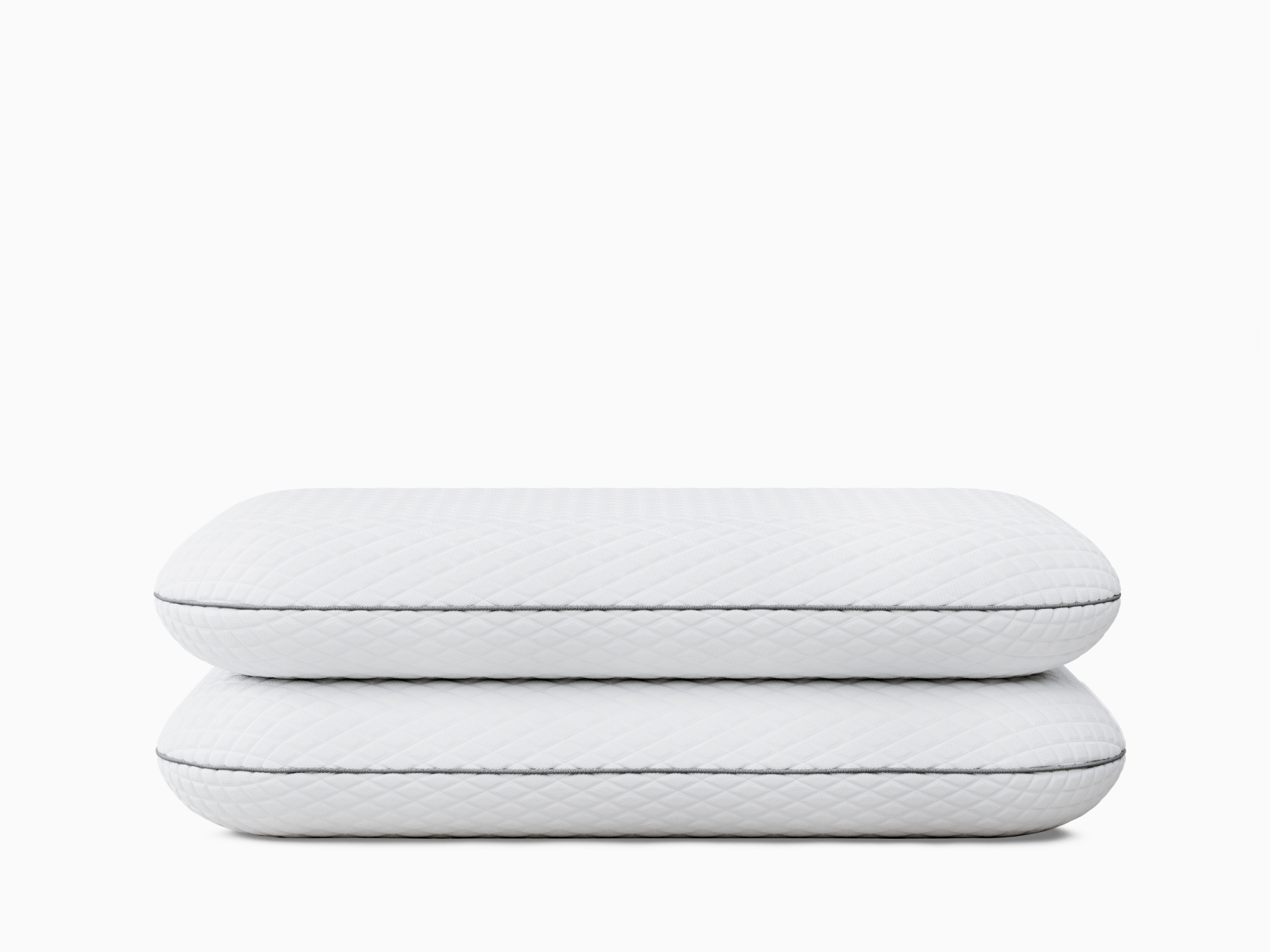 Two white pillows stacked, featuring diamond stitching and grey piping