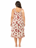 Back view of a woman in a cream and red floral print nightgown.