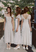 Close-up of the neckline and bodice of a cream-colored jacquard midi dress.