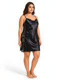 Woman wearing a black satin slip dress with lace insets from the side.