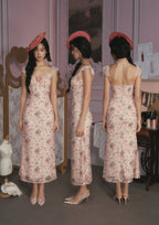Back view of a pink floral print midi dress with lace trim.