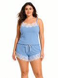 Front view of a smiling woman wearing a light blue ribbed knit camisole and shorts set with white lace trim.