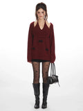 woman wearing a burgundy knit sweater with black bows