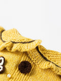 Close-up of the ruffled neckline of the yellow knitted pet sweater.