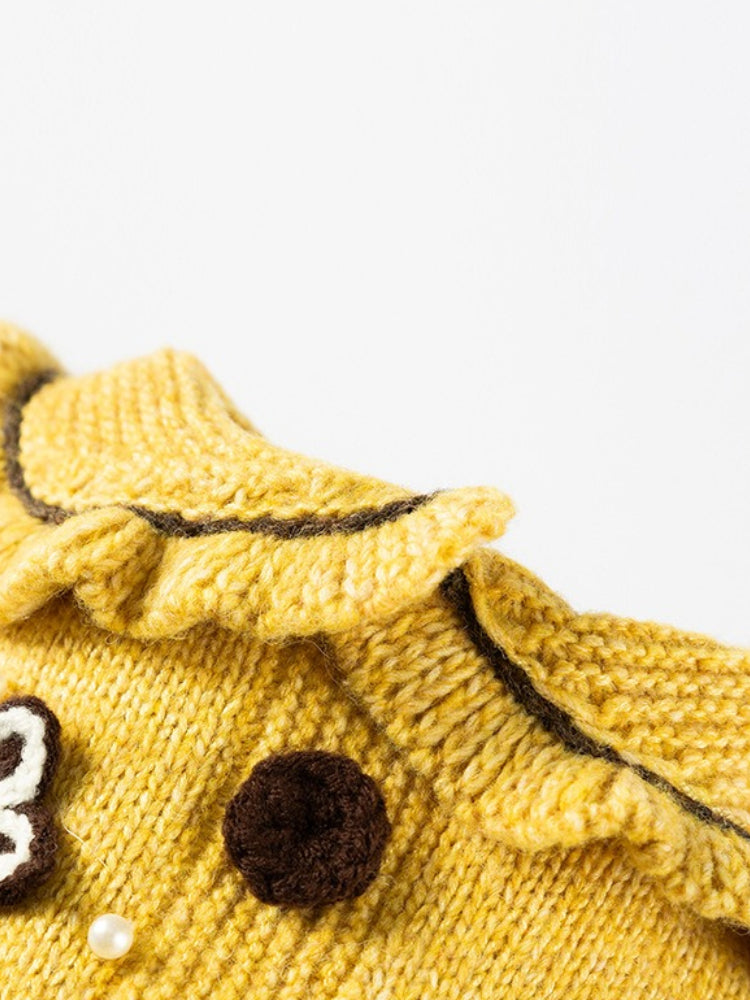 Close-up of the ruffled neckline of the yellow knitted pet sweater.