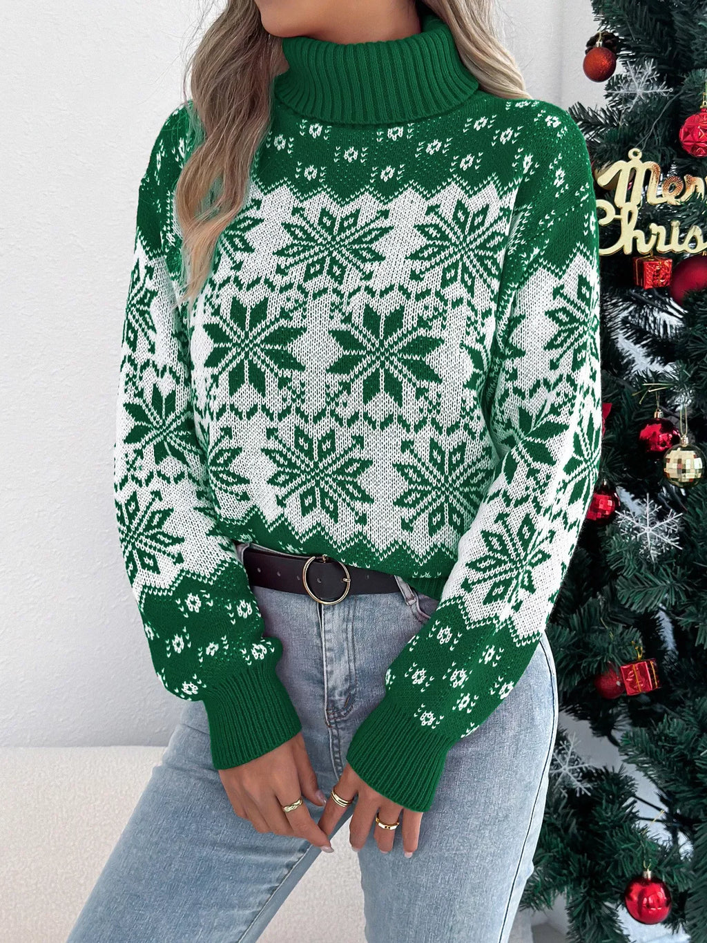 Woman wearing a green and white snowflake pattern turtleneck sweater, front view, showing detail.