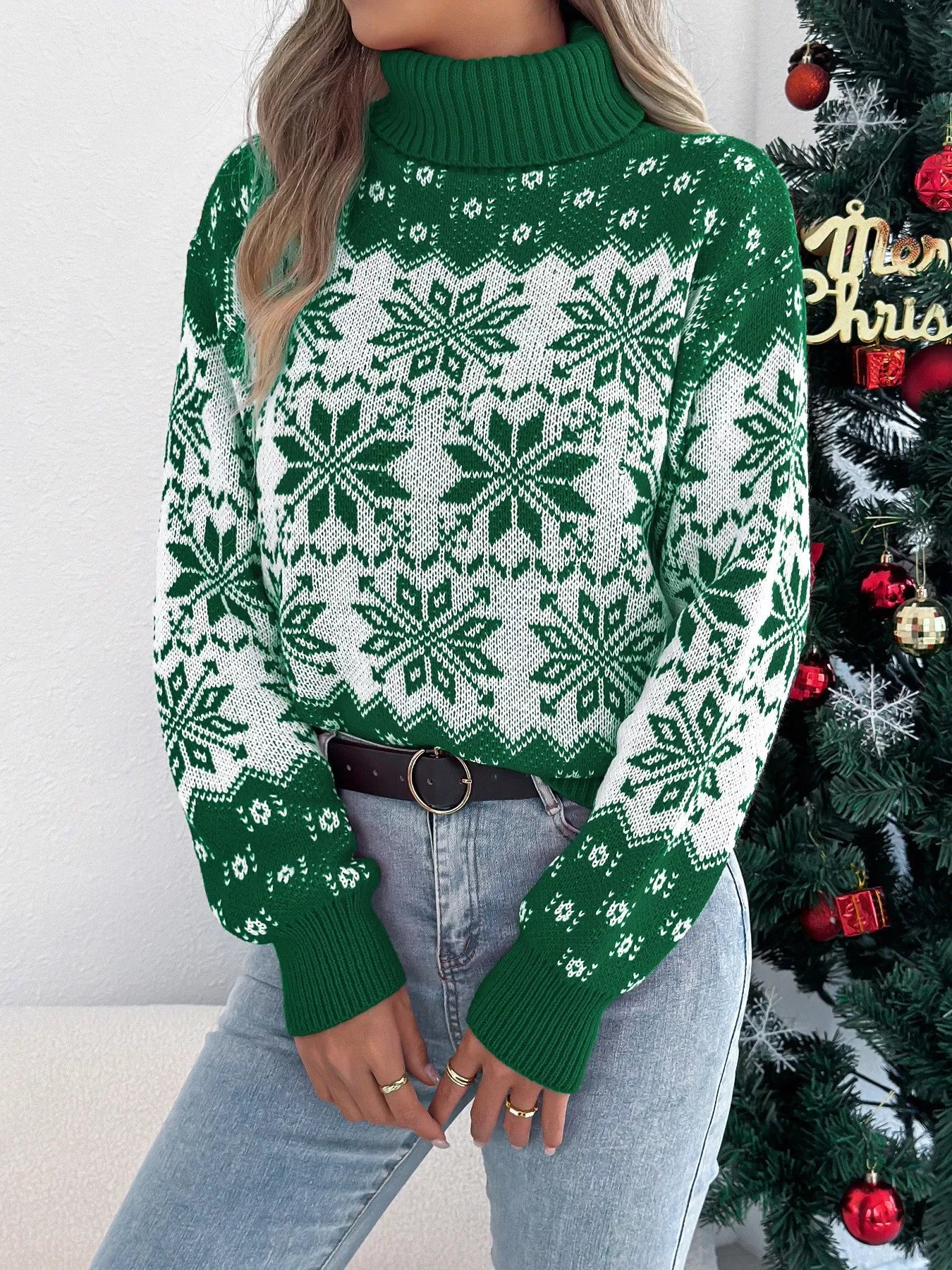 Woman wearing a green and white snowflake pattern turtleneck sweater, front view, showing detail.