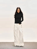 Full body shot of a model in a black fitted turtleneck top and wide-leg cargo pants.