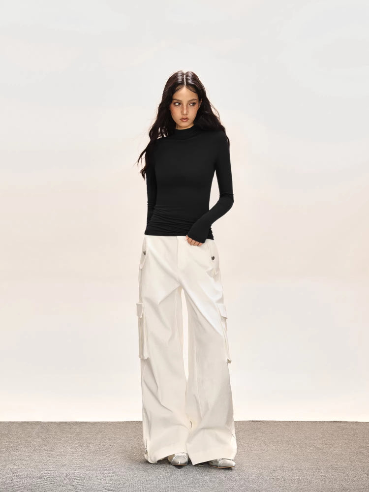 Full body shot of a model in a black fitted turtleneck top and wide-leg cargo pants.