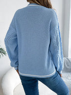 Back view of a woman in a light blue cable knit sweater