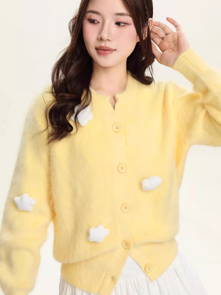Woman posing in a yellow fuzzy knit cropped cardigan with cloud details.