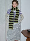 Model wearing a striped knit scarf and casual outfit