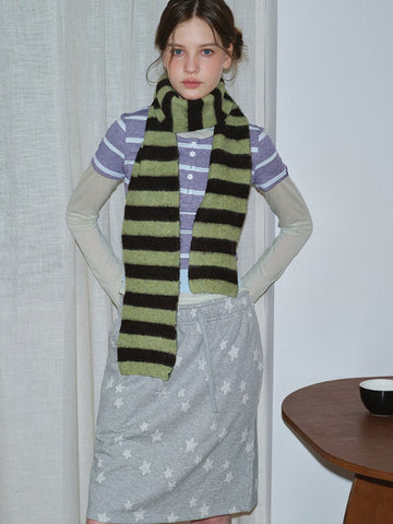Model wearing a striped knit scarf and casual outfit