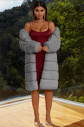 Model in a grey faux fur coat over a satin dress