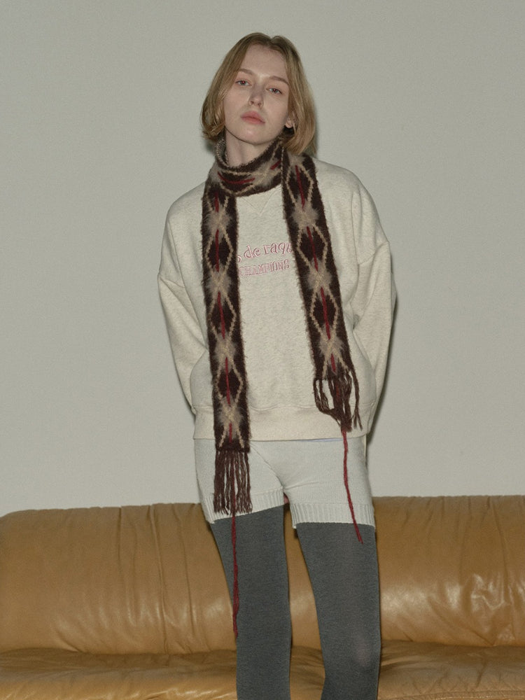 Close-up of a woman wearing a casual outfit with a textured scarf.