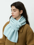 Woman wearing a light blue knit scarf