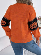 Back view of the orange knit sweater with lantern sleeves.