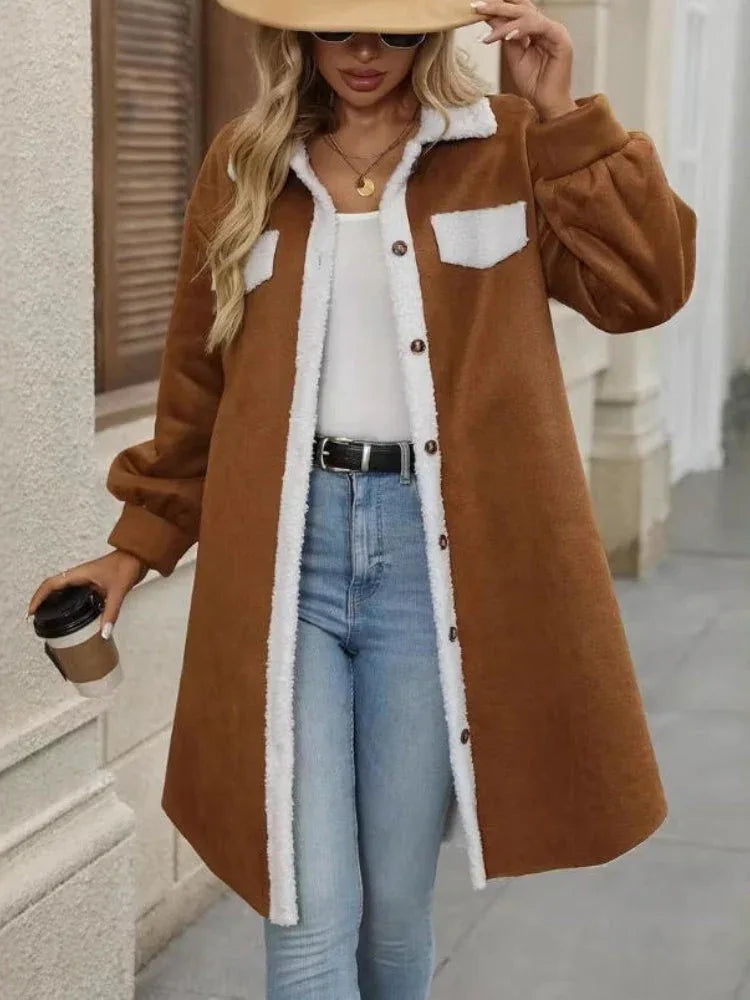 Woman wearing a long brown fleece shirt jacket with white sherpa trim and two chest pockets.