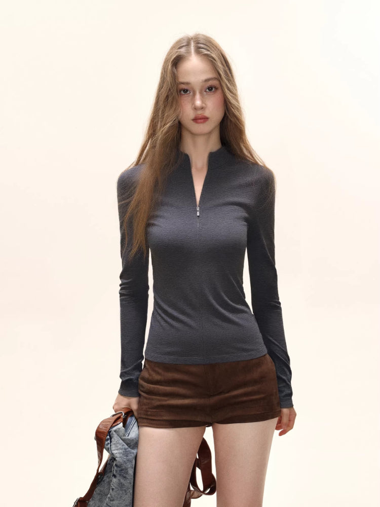Model wearing a dark grey long-sleeve zip-up top with brown shorts.