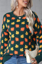 Close-up of the leaf print detail on a dark green knit sweater.