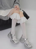 A person sitting down, showcasing white lace ankle cuffs with ruffled trim.
