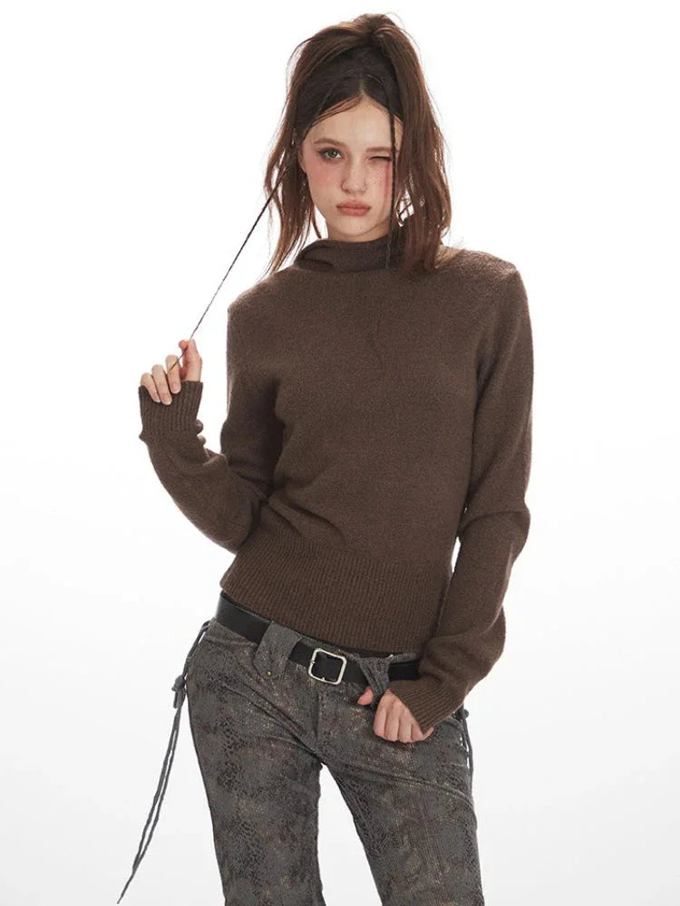 Close-up of a woman wearing a brown turtleneck sweater and patterned pants