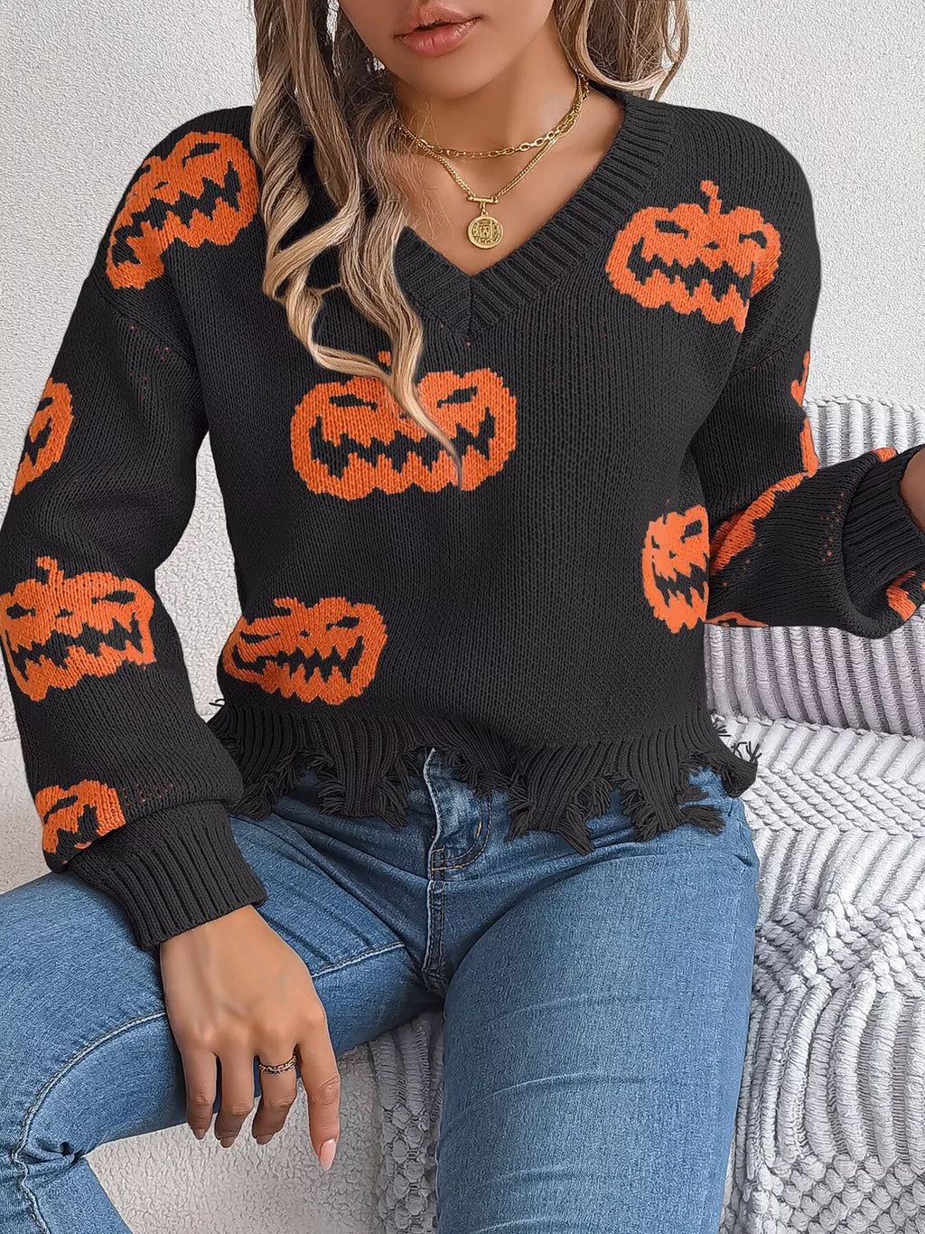 Close-up of distressed hem on pumpkin knit sweater