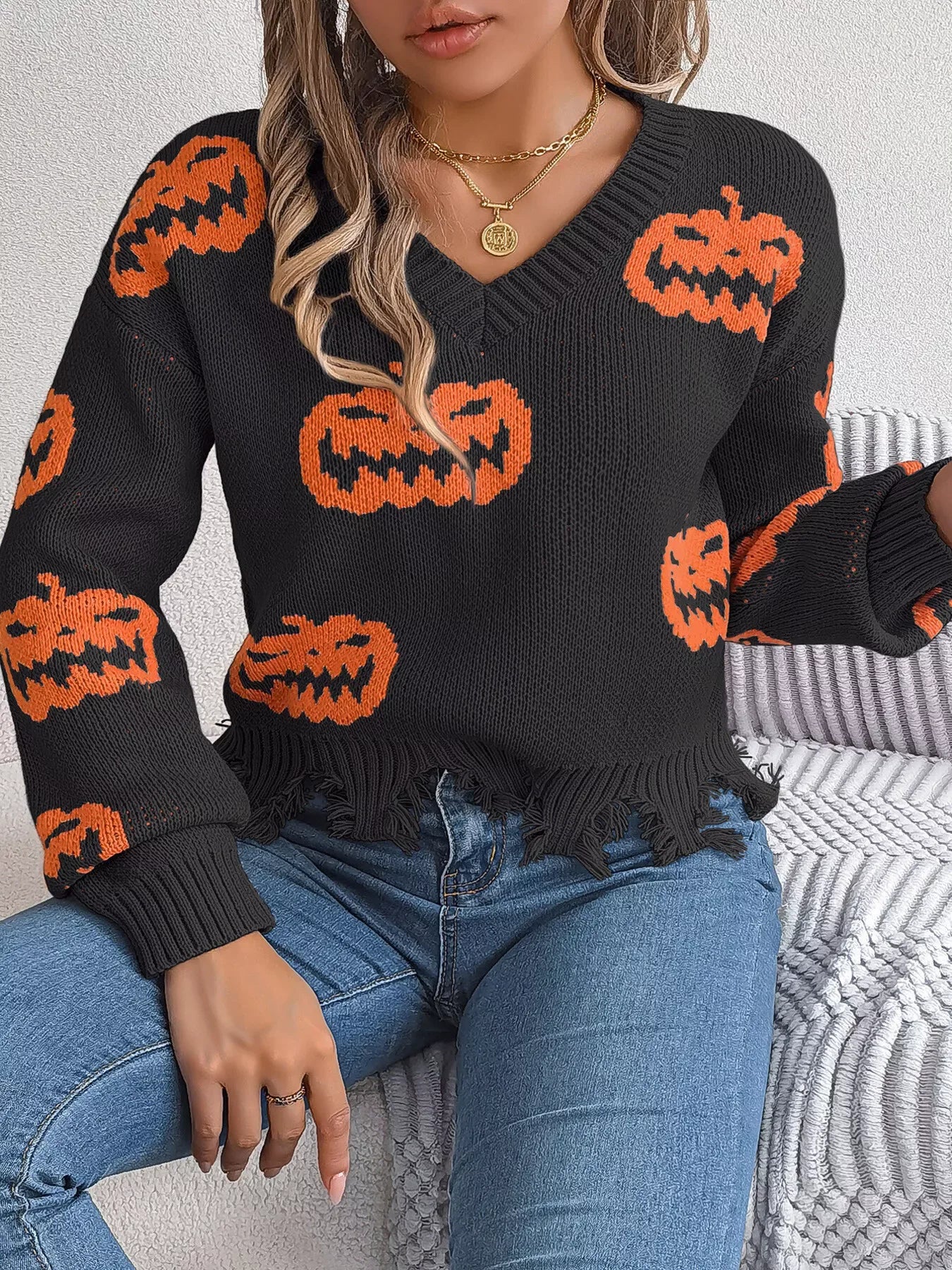 Close-up of distressed hem on pumpkin knit sweater