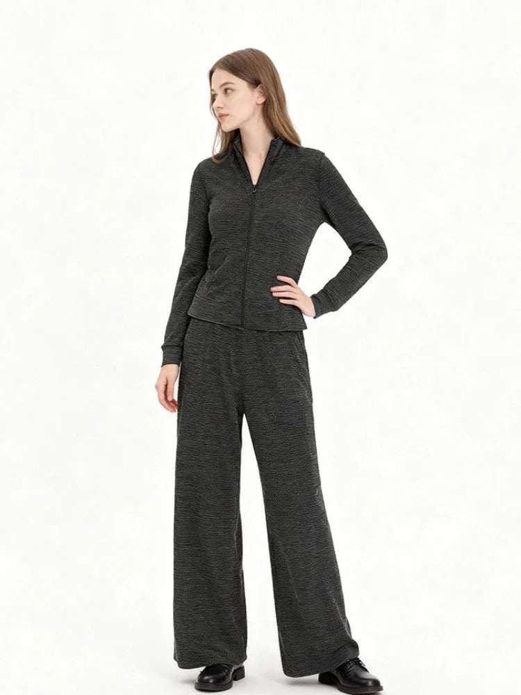 Woman wearing a charcoal grey knit loungewear set with a full zip jacket and wide leg pants, front view.