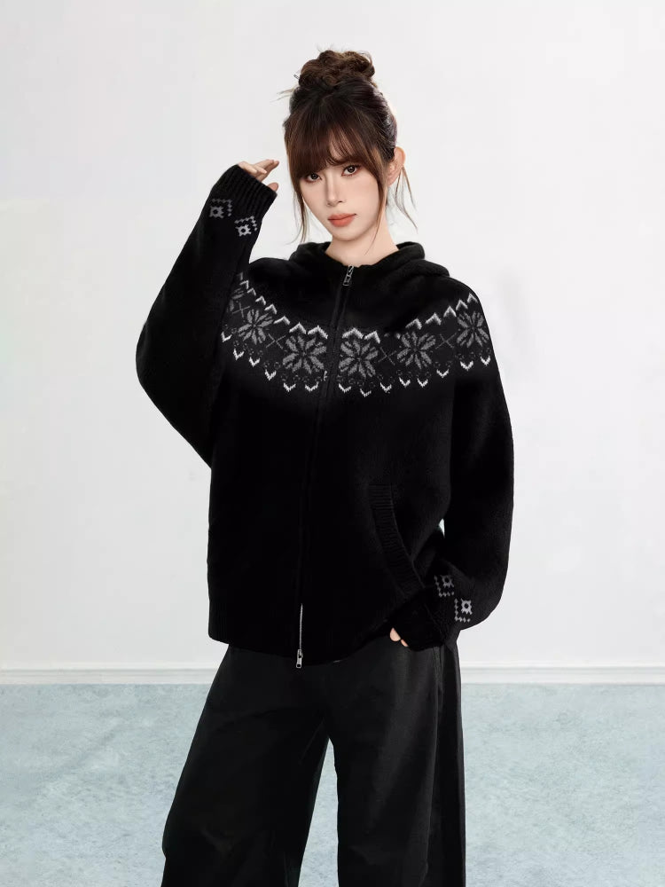 Woman wearing a black Fair Isle knit hoodie with snowflake pattern and zipper