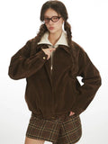 Close-up of a woman wearing a brown corduroy bomber jacket, showing the zipper detail.