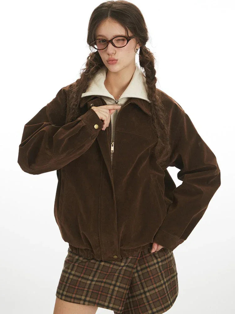 Close-up of a woman wearing a brown corduroy bomber jacket, showing the zipper detail.