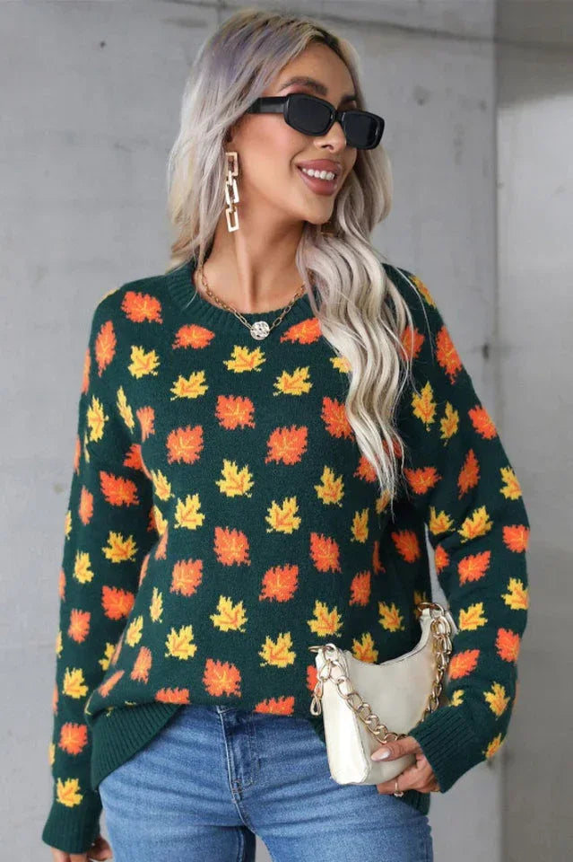 Woman smiling while wearing a dark green leaf-patterned sweater.