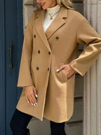 Close-up of a woman in a camel double-breasted coat, showing the lapel and buttons.