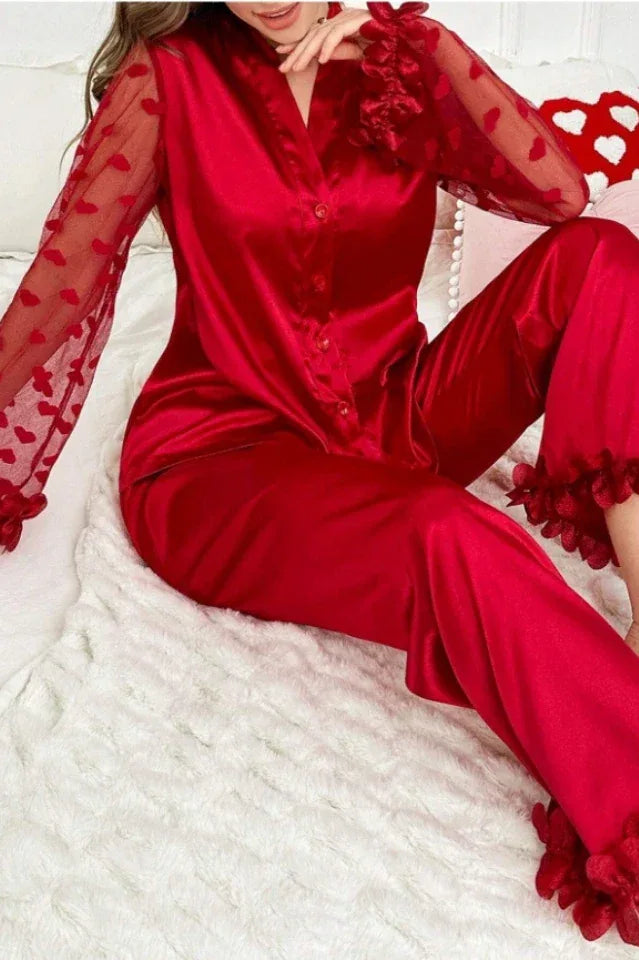 Close-up of a woman in a red satin pajama set, highlighting the sheer sleeves and ruffled details