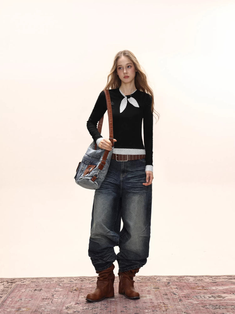 Model wearing a black long-sleeve top with white polka dot trim and scarf detail